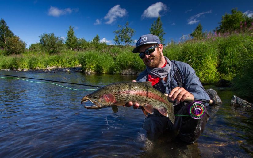 Campfire Collective Ambassador Christiaan Pretorius holding up rainbow trout caught with mouse.